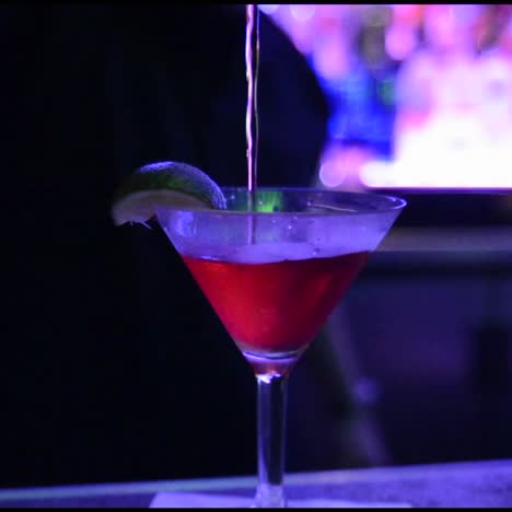 camarero vertiendo un cóctel agitado en un vaso frío en una discoteca en san diego, california