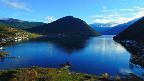 a view of the pier in a norwegian village kaupanger with moored boats along the beautiful shore of sognefjorden in sogndal in vestland county, norway