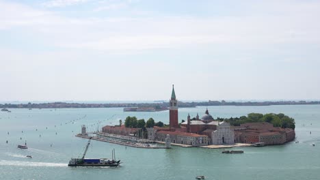 aerial of merchant ship sailing by san giorgio maggiore in venice, 4k