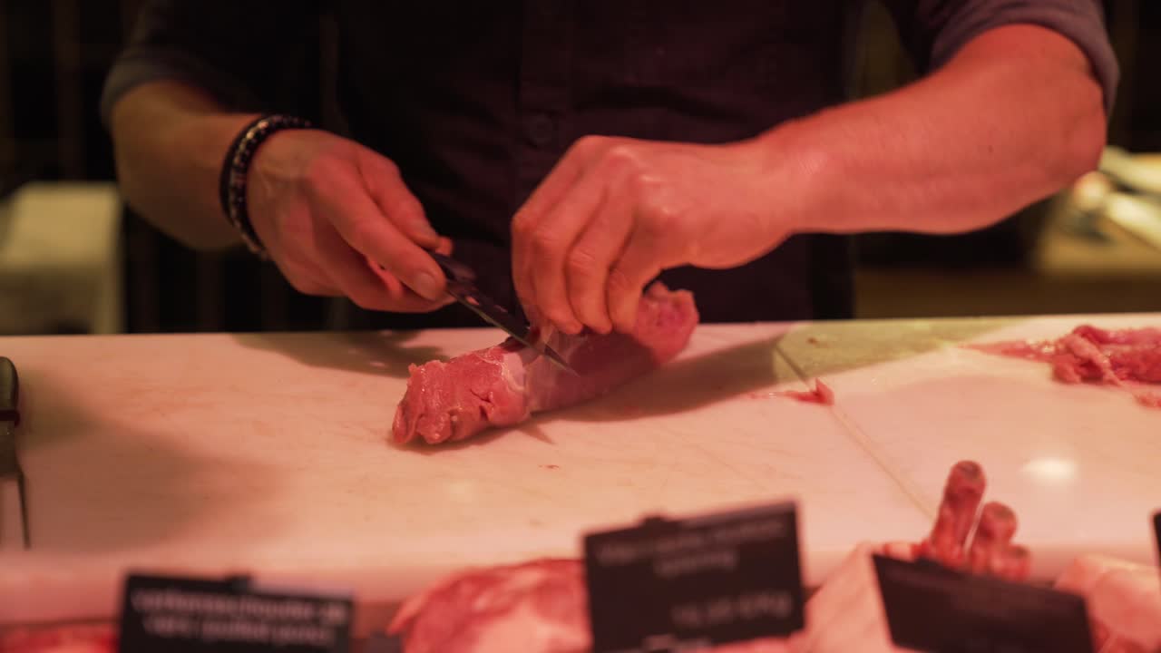 Hands of butcher slicing meat at butchery