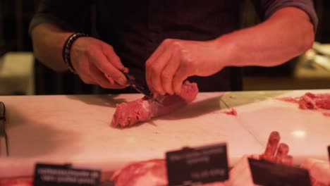 hands of butcher slicing meat at butchery
