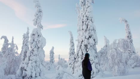 girl walking up street, explores beautiful snow covered winter wonderland in lapland, finland, arctic circle