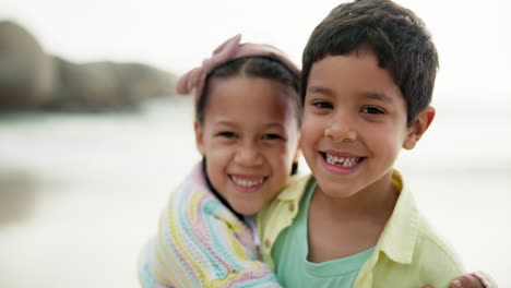 happy siblings hugging at the beach