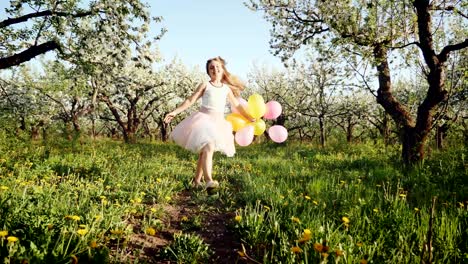 happy girl with balloons running in the garden