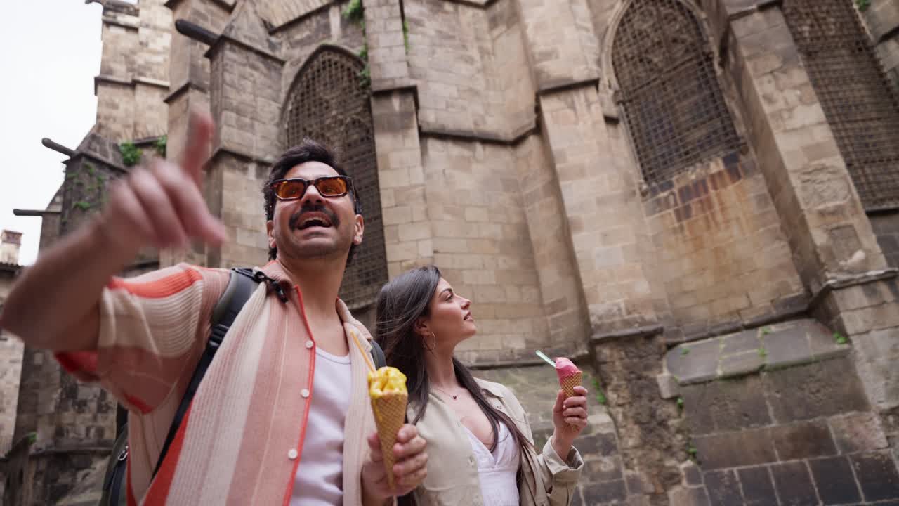 Coppia felice che mangia gelato e visita una città storica