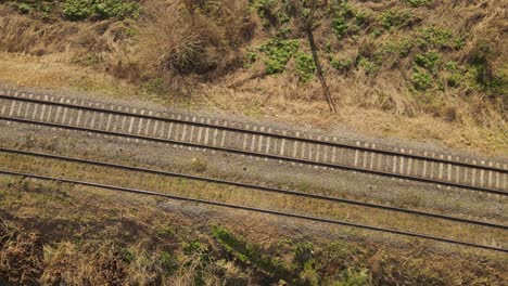 aerial top down of railroad tracks in rural area during sunny day - ascend drone