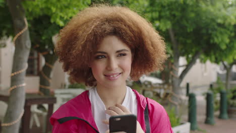retrato en primer plano de una joven estudiante adolescente linda sonriendo mirando pensativa disfrutando de mensajes de texto navegando usando un teléfono inteligente mujer relajada en la ciudad