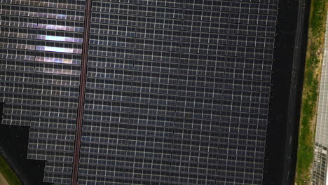 el sol se refleja en los techos de vidrio de los invernaderos masivos, vista aérea de arriba hacia abajo