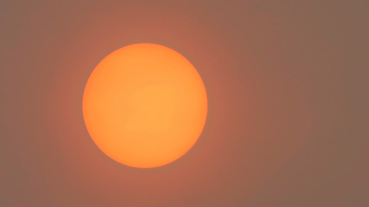 la luz del sol oscurecida por el polvo del sáhara y el humo de los incendios forestales