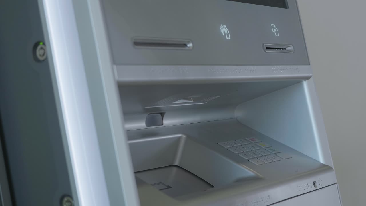 Person inserting credit card into ATM