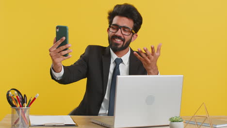 Indian-businessman-making-phone-call-online-conversation,-mobile-loudspeaker-talking,-waving-hello