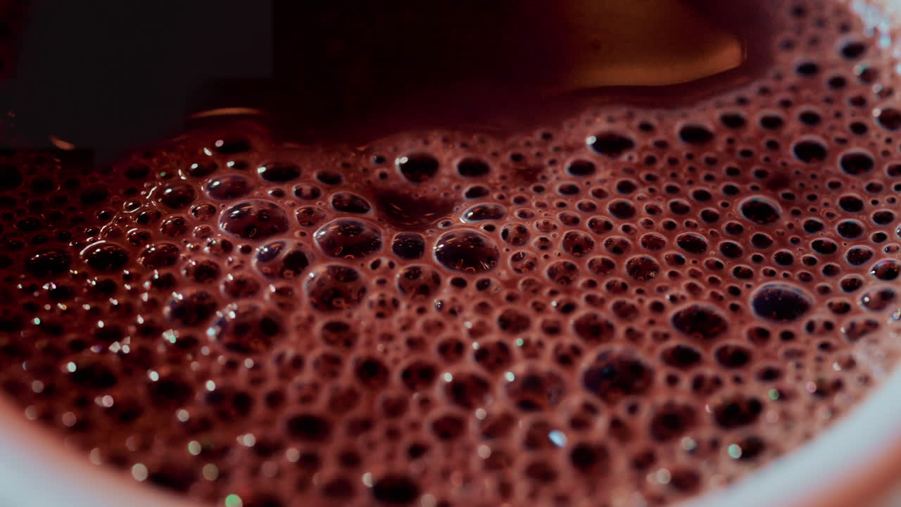 Top down close up of a warm cup of hot chocolate covered in foamy bubbles