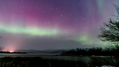 starry night skies with colorful aurora borealis over the river in finland. - time lapse shot