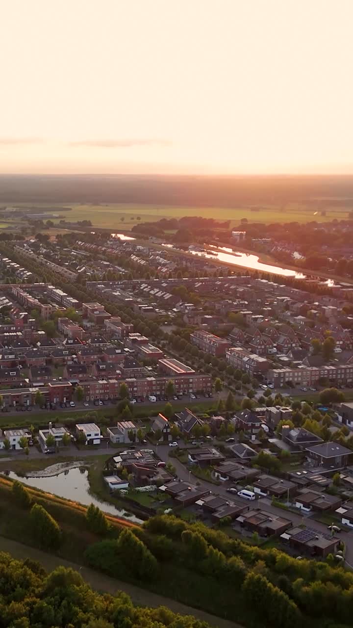 Aerial view of a residential neighborhood at sunset with a river