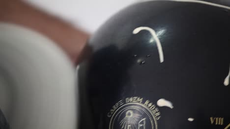 disparo de mano de un amortiguador mecánico pulindo la superficie de un nuevo casco de motocicleta negro