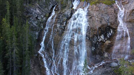 drone ascending showing a set of waterfalls in a natural rocky environment in canada