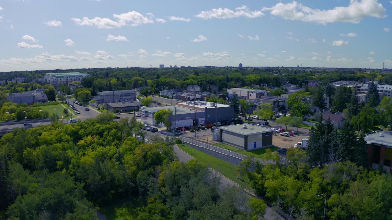 Panaramic aerial 180 degrees over road leaving the downtown core and headed South East past the North Saskatchewan River flyover the historic steam paddle boat by the lusg green sunny public park