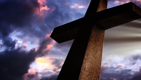 silhouette of a cross with dark clouds and sparkling rays