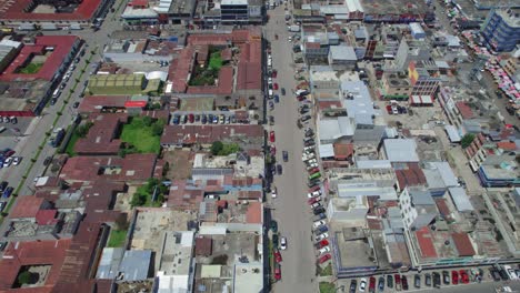 Drone-aerial-footage-of-Central-American-urban-colonial-city-streets-of-Quetzaltenango-Xela,-Guatemala-with-people-and-traffic-on-the-streets
