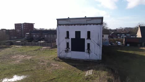 closeup aerial pan around former youth prison facility, now abandoned waiting for demolition and refurbishment of the moated plot field in a residential neighbourhood of zutphen, the netherlands