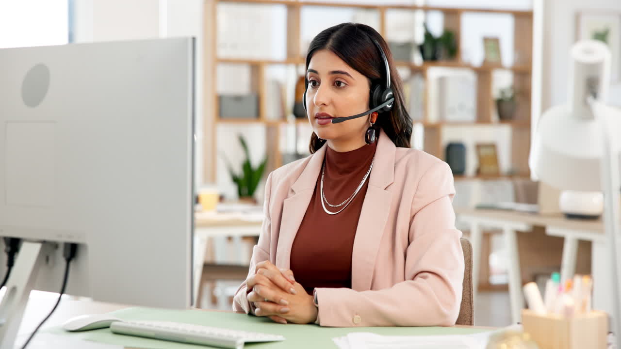 Young Woman Wearing Headset Working on Computer in Modern Office