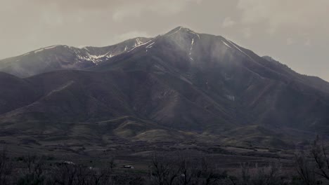 clouds pass in front of an ominous mountain