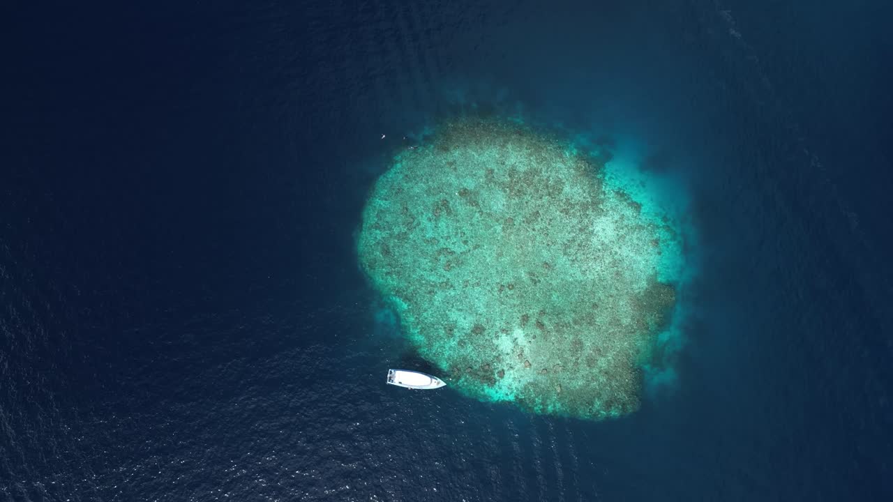 dream vacation holiday scene aerial top down little island with boat moored at bay in Maldives Indian Ocean remote isolated lonely island in tropical environment