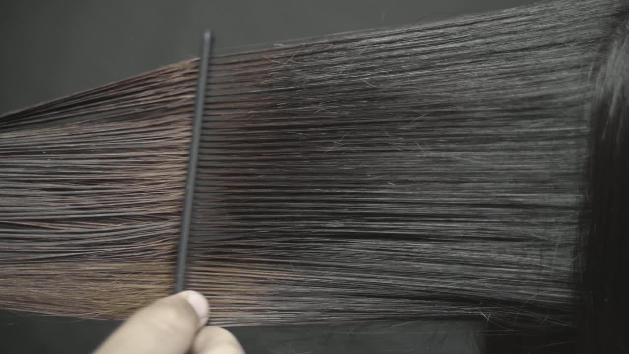 미용사는 머리를 깎는 동안 긴 갈색 여성의 머리를 빗고,