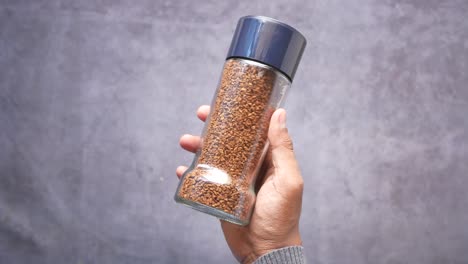 hombres sosteniendo un frasco de polvo de café en la mesa