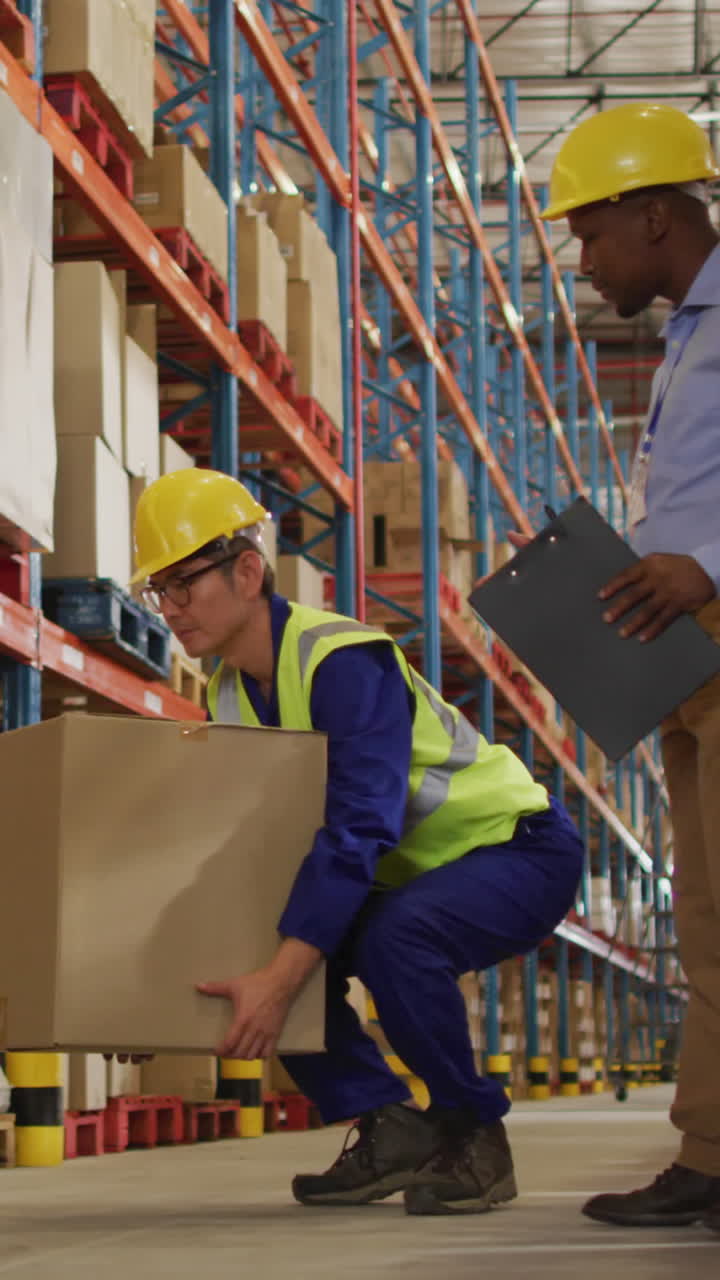 trabajadores varones diversos que usan casco y llevan cajas en el almacén