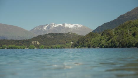 Small-waves-on-surface-of-Wilson-bay-in-Wakatipu-lake,-distant-mountain-range,-New-Zealand