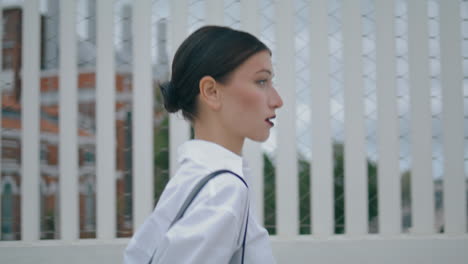 Confident-lady-walking-smartphone-on-street-close-up.-Woman-hurrying-vertical