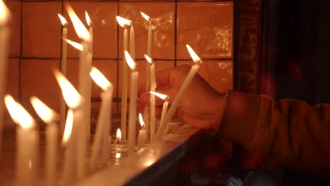 encendiendo velas votivas en una iglesia