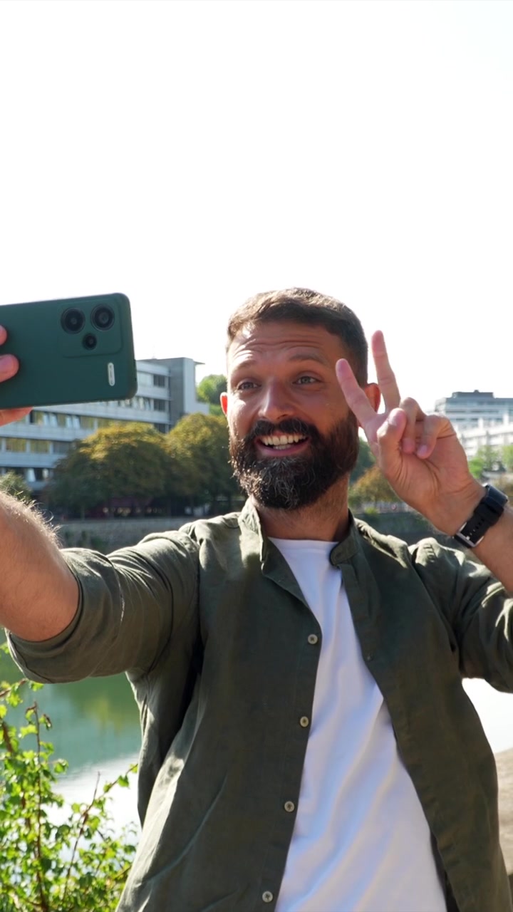 Uomo felice che si fa un selfie all'aperto lungo il fiume