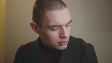 Serious-Young-Man-Staring-To-The-Side-Then-To-The-Camera-Isolated-On-Gray-Background---Closeup-Shot