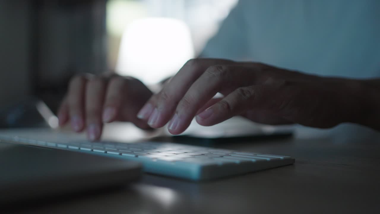 close up hands working overtime typing research laptop office desk at night