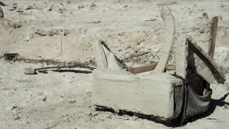 Reste-Von-Verfallenem-Stuhl-Liegen-Im-Sand-In-Der-Trockenen,-Trockenen-Wüste