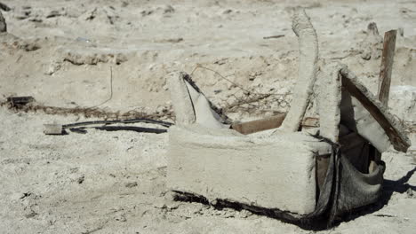 los restos de una silla en descomposición se sientan en la arena en un desierto seco y árido.