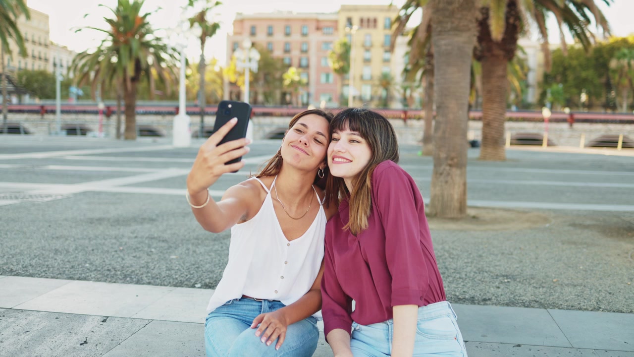 Mujeres jóvenes felices tomándose una selfie juntas al aire libre