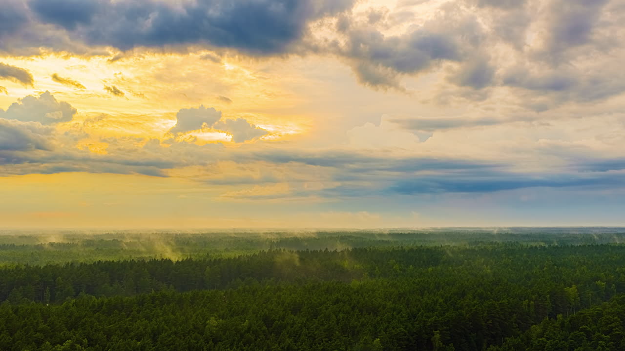 Hyperlapse of a dramatic sunset over lush forest with moody clouds