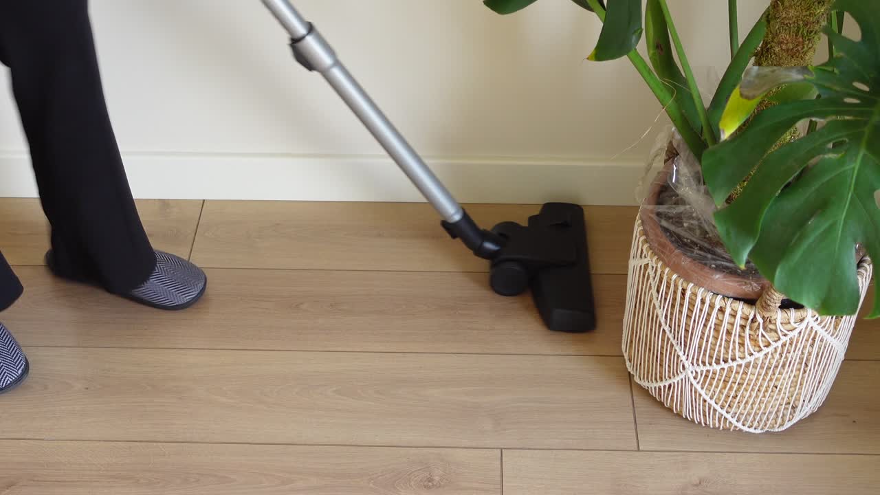 una mujer aspirando el suelo de su casa.