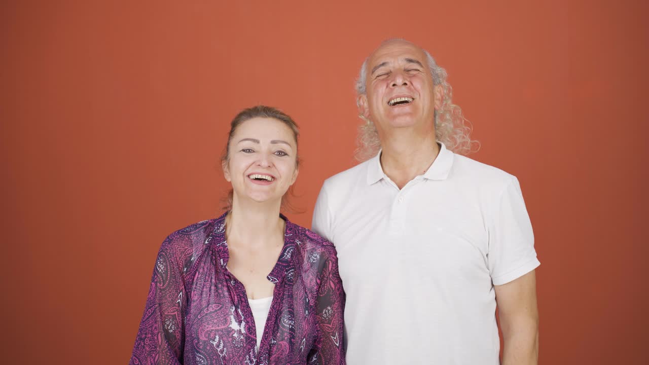 커플이 카메라에 손을 흔들고 있습니다.