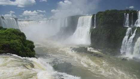 Olas-Dramáticas-Rompiendo-En-El-Suelo-Rocoso-De-La-Piscina-Desde-Un-Enorme-Valle-De-Cascada,-Vista-Pintoresca-En-Cámara-Lenta-Del-Increíble-Paisaje-Rocoso-Del-Borde-Del-Acantilado-En-La-Caída-De-Iguazú,-Destino-Argentino,-América-Del-Sur