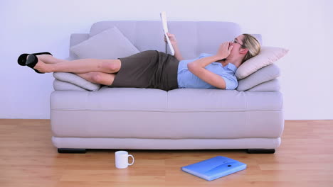 Stylish-tired-businesswoman-falling-asleep-on-couch