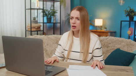 woman upset about unpaid bill at home on table closing laptop feeling bankrupt blocked payment
