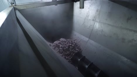 industria pesquera: una tubería que vierte partes de pescado en un tanque de recolección