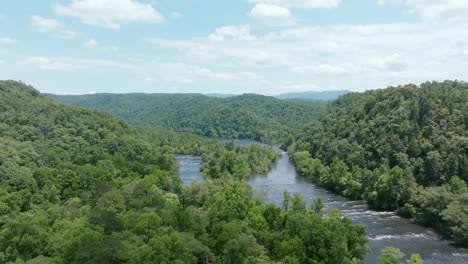 wide aerial footage of the branching hiawassee river in north east tennessee during the summer with green forest all around.