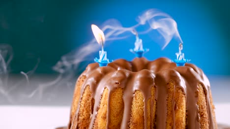 blown out (twice)birthday candles on marble cake with chocolate nougat icing