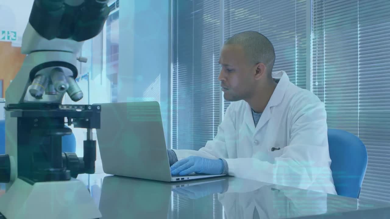 Animation of scientific data over african american male lab worker using laptop