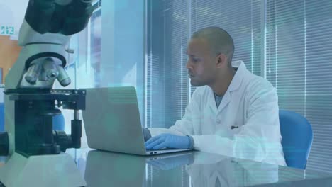 animación de datos científicos sobre un trabajador de laboratorio afroamericano usando una computadora portátil